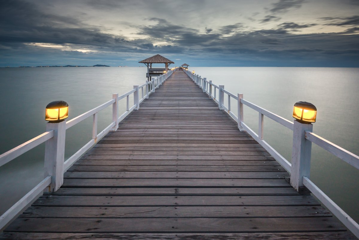 Scenic pictures of wooden bridge on the sea at night