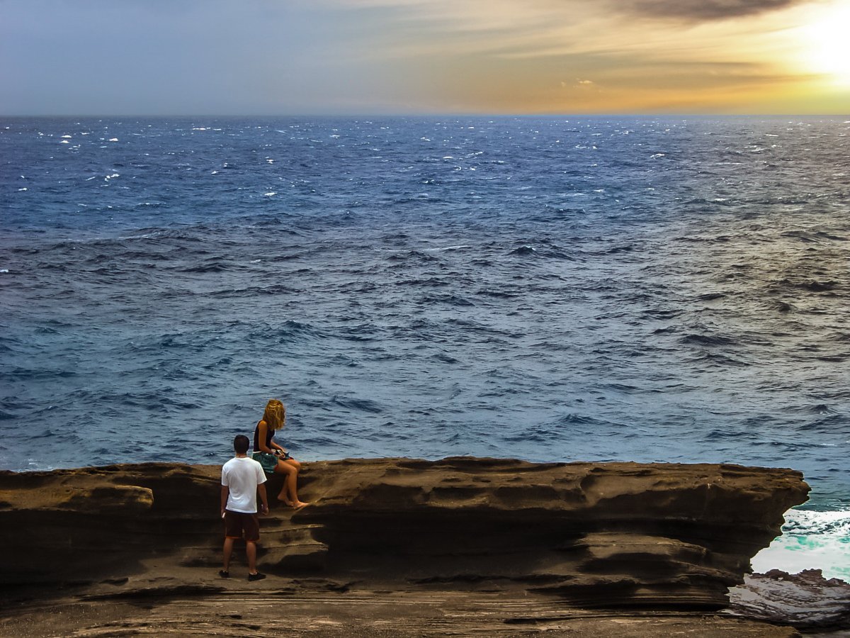 Picture of two people watching the waves of the sea