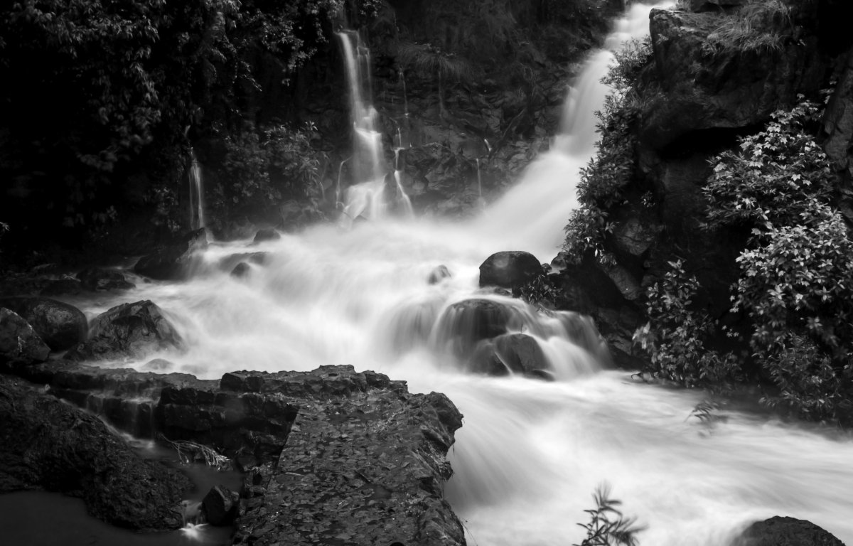 Black and white picture of mountain waterfall flowing water
